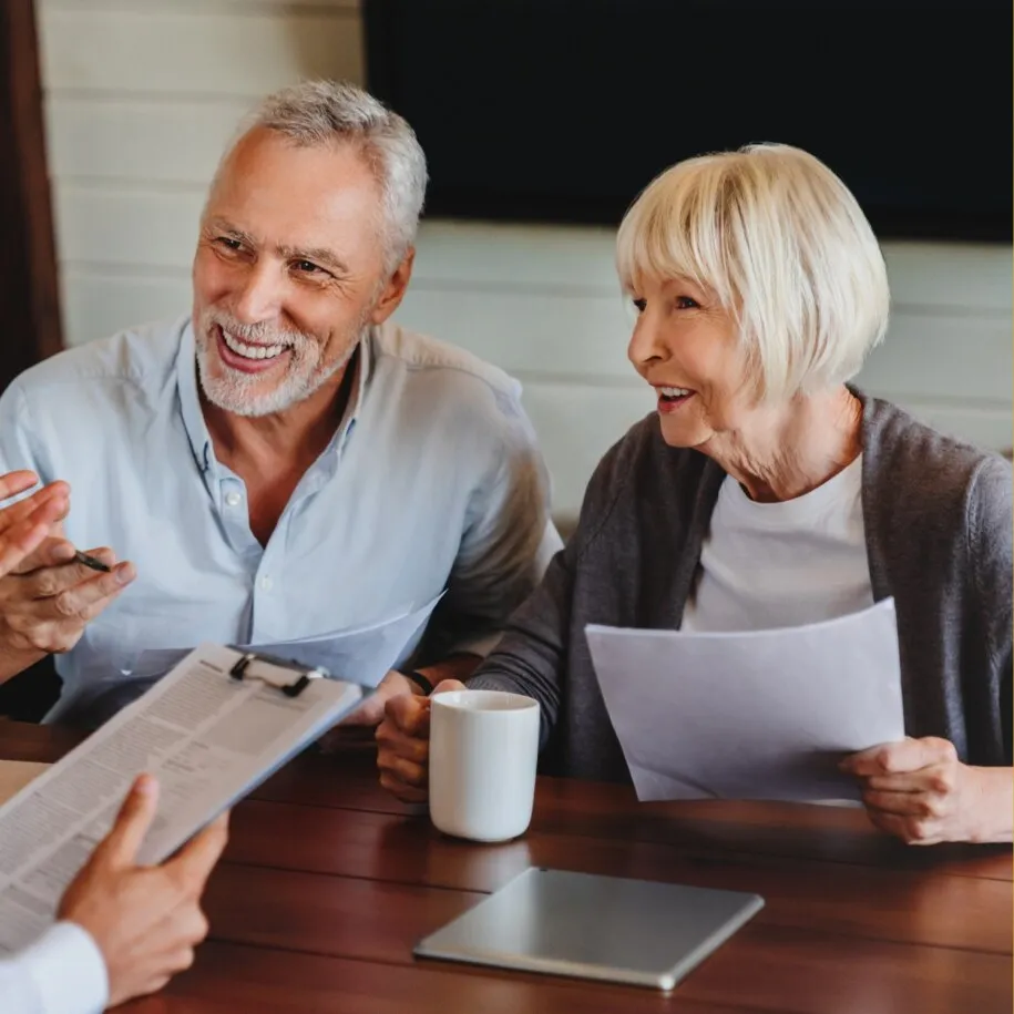 A couple reviewing estate planning documents with their attorney across a conference table